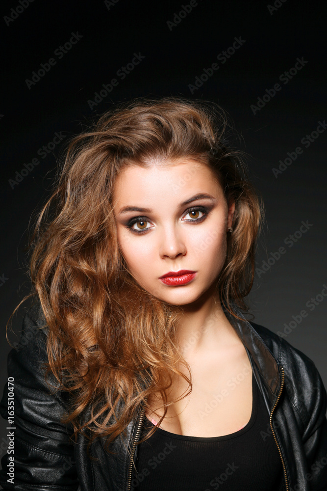 Portrait of beautiful brunette female wearing leather jacket Portrait of beautiful brunette female wearing leather jacket