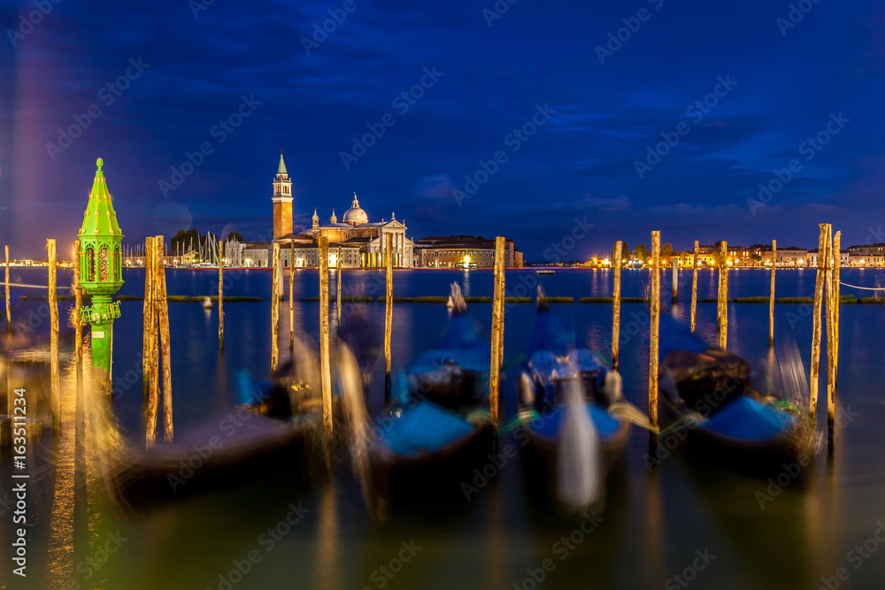 Blurred Gondolas Moored At Pier With Church Of San Giorgio Maggiore In Background