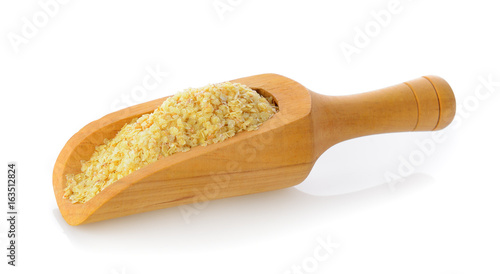 Wheat germ in wood scoop on white background