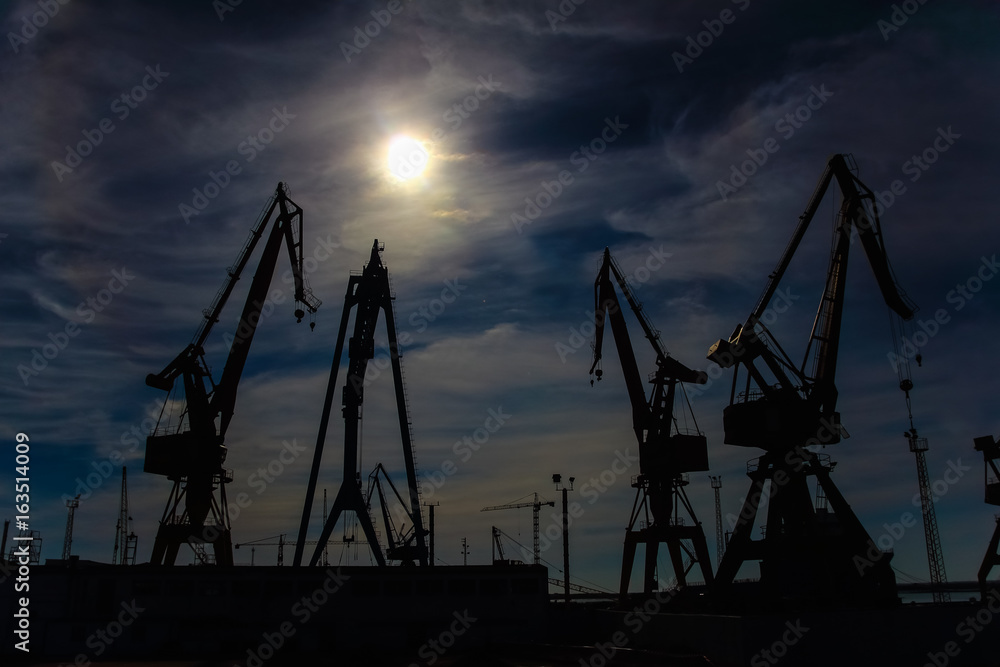 Beautiful landscape of  cranes in shipyard  against a backlight