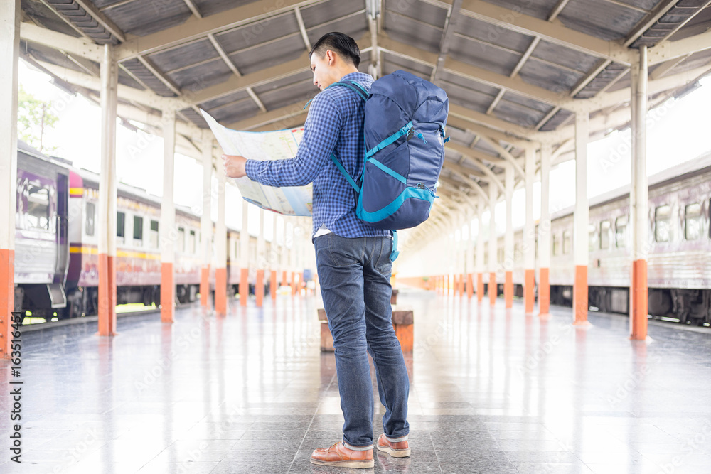 Obraz premium man traveler with backpacker look searching location at trainstation