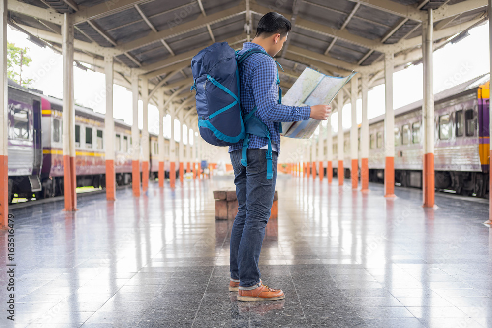 man traveler with backpacker look searching location at trainstation