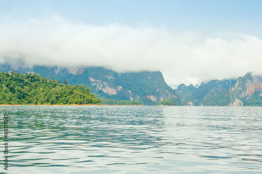 landscape with mountains trees and mist and a lake in front,Evening after heavy rainy day. Poor lighting conditions landscape with mountains trees and mist and a lake in front,Evening after heavy rainy day. Poor lighting conditions