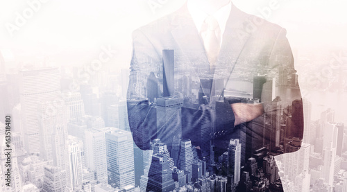 Business man standing on roof with city in the background