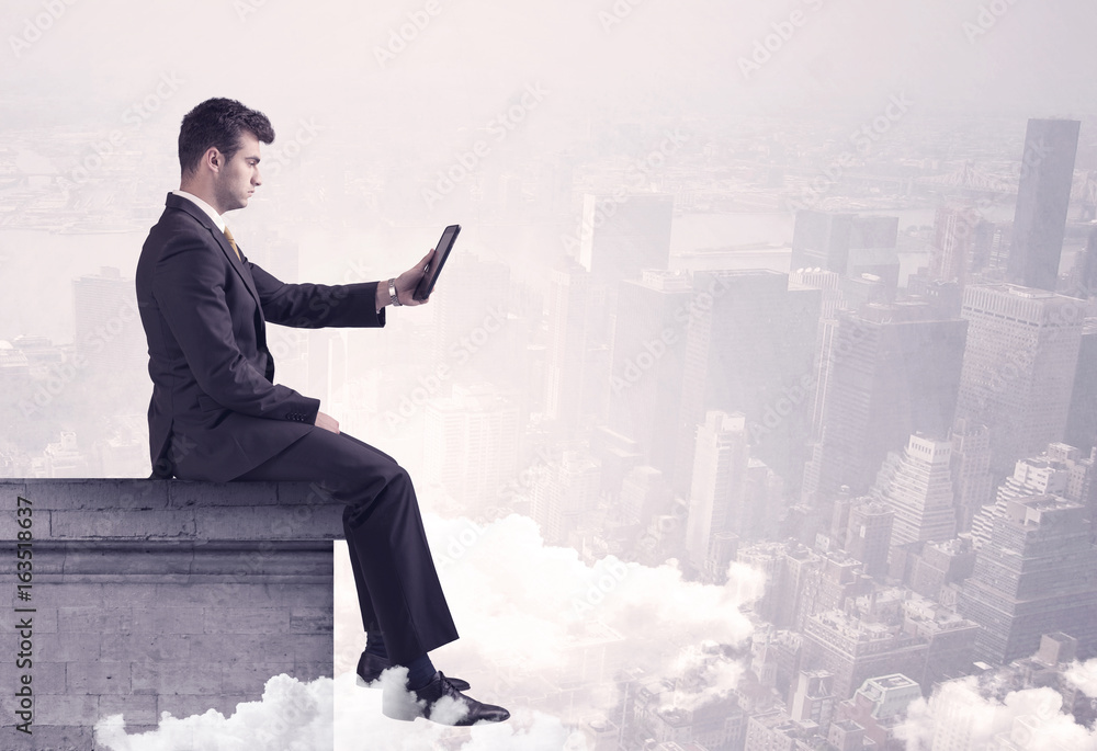 Sales person sitting on building edge in city Sales person sitting on building edge in city