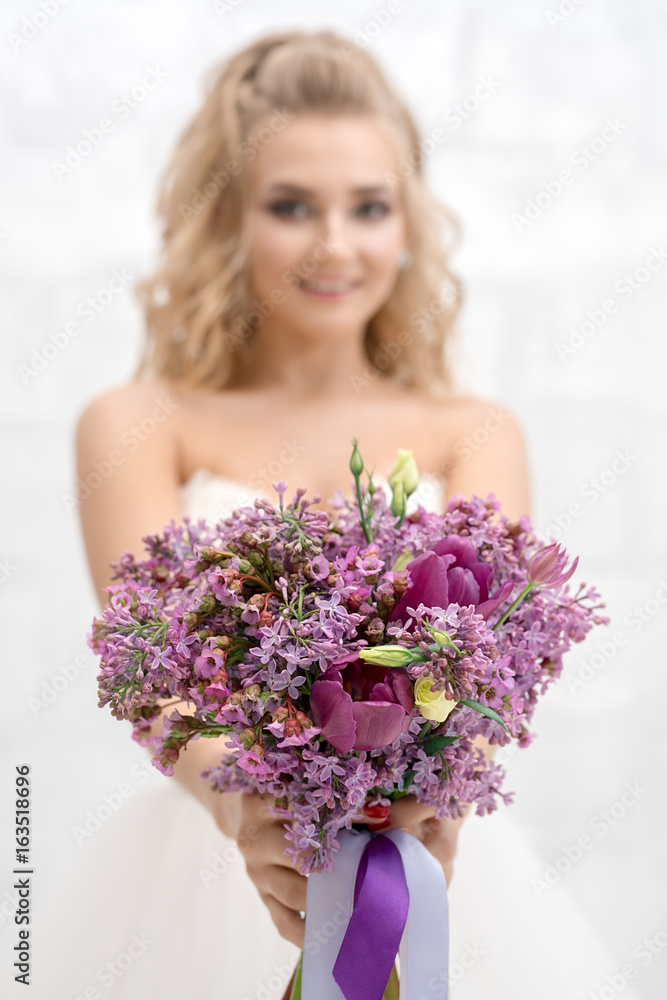 Beautiful bride in studio with exquisite bouquet