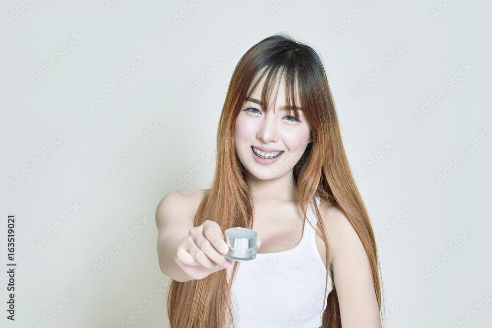 Asian woman holding white whitening cream bottles Asian woman holding white whitening cream bottles