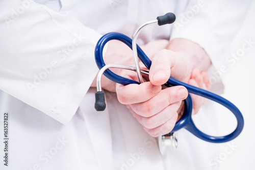 close up doctor hand holding stethoscope