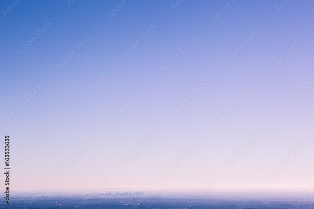 Small silhouette of Melbourne CBD skyscrapers in urban fog with lots of blue sky for copy space Small silhouette of Melbourne CBD skyscrapers in urban fog with lots of blue sky for copy space