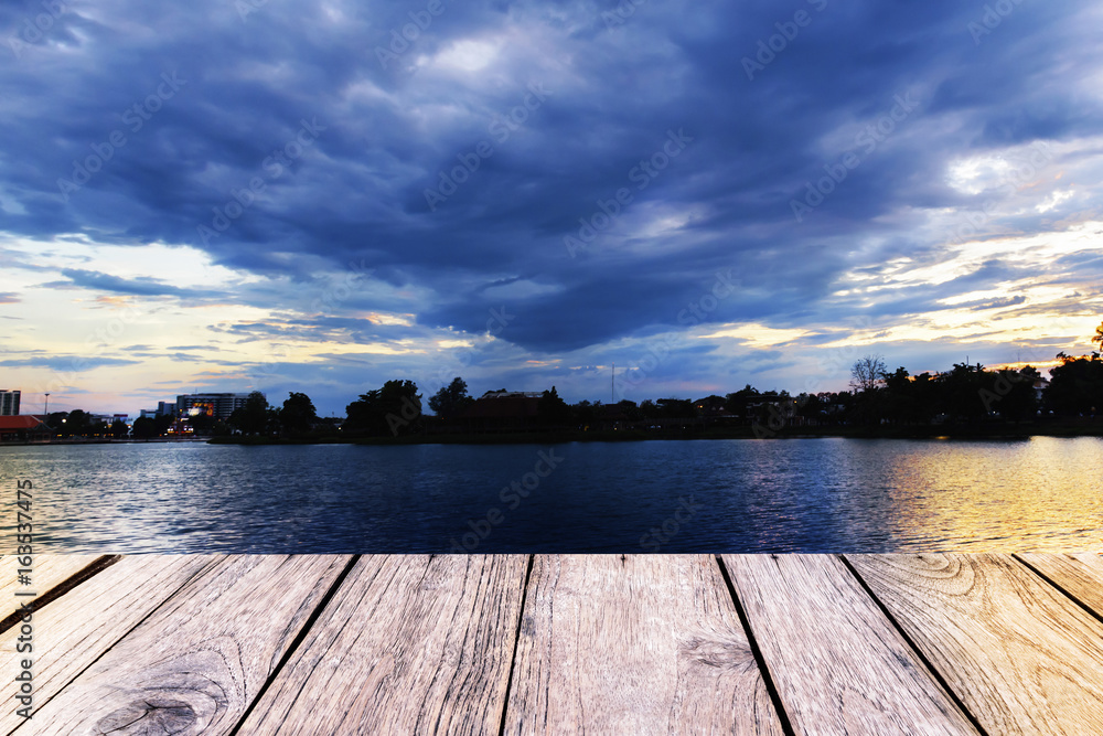 Empty top wooden table on city landscape at sunset background