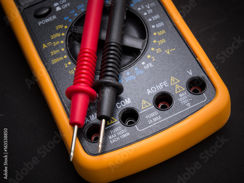 Multimeter and tester on black background
