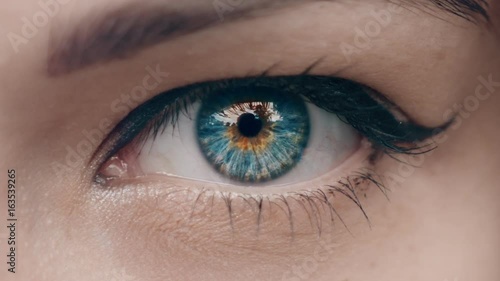 Young Woman is opening and closing her beautiful eye. Macro Close-up eye blinking.