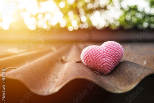Pink heart knitting on roof in mornig sun. photo