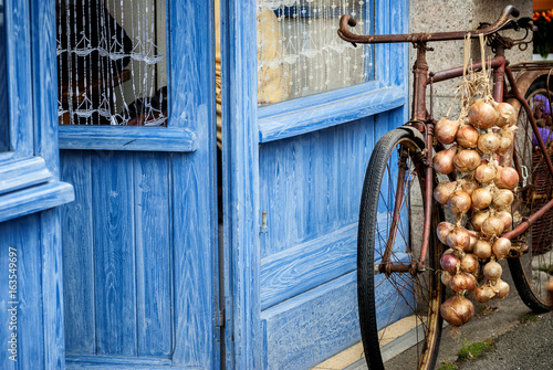Fotografi Bicycle with pink onion braid of Roscoff