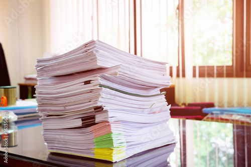 Close up paper stack on the desk related to business functions.Stack of business document files,report paper of accounting and financial with morning light,soft focus