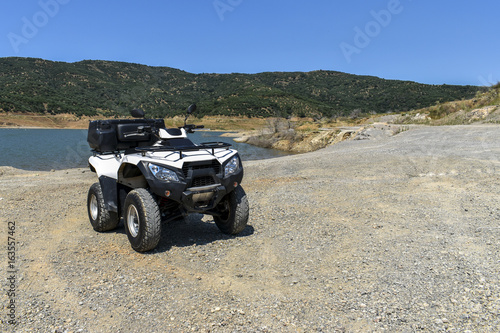 ATV offroad on mountain and sky background.