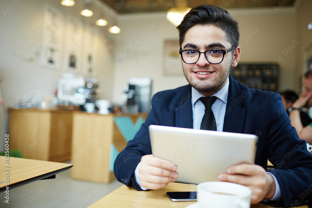 Young manager with touchpad spending time in cafe Young manager with touchpad spending time in cafe