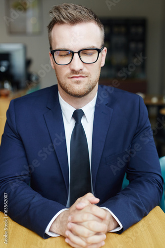 Businessman with closed eyes concentrating on thoughts