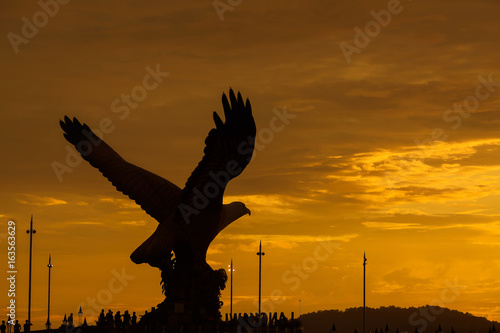 Silhouette of majestic Eagle Statue in Langkawi during beuatiful golden sunset.