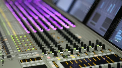  Professional audio mixer. A small depth of field, flickering light bulbs.Hands of Audio engineer working. Sound engineer, producer control engineer, audio mixing console