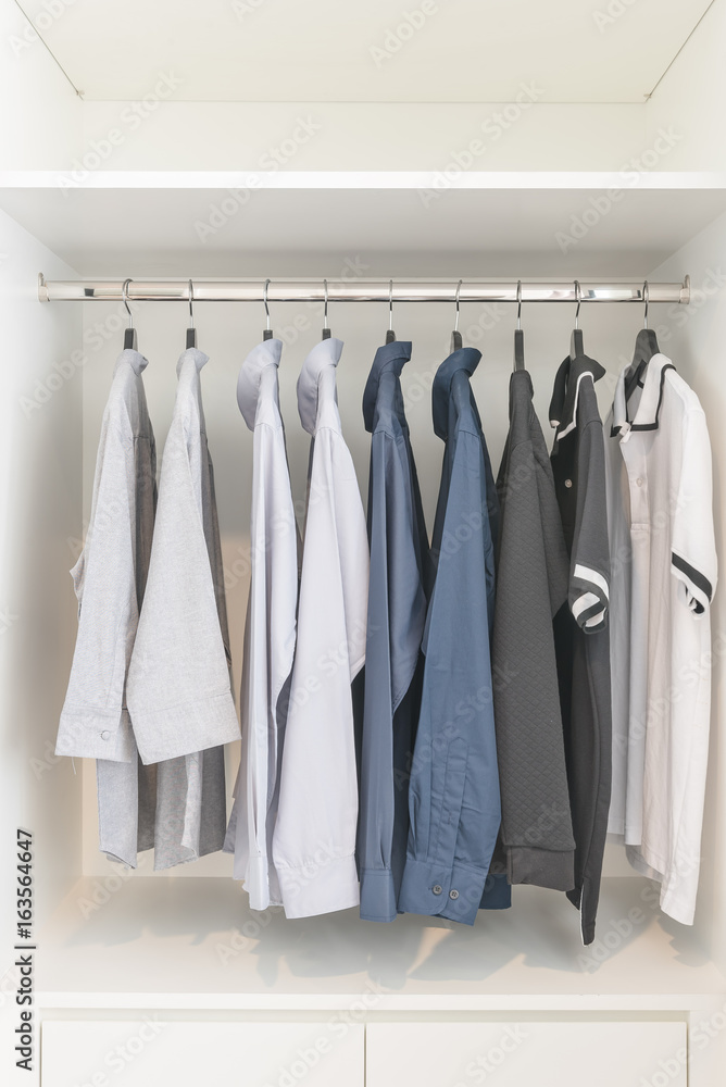 clothes hanging on rail in wooden white wardrobe clothes hanging on rail in wooden white wardrobe