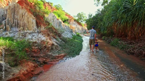 Father Daughter Walk along Shady Fairy Stream Backside View