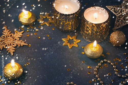 Fototapeta Naklejka Na Ścianę i Meble -  Christmas festive background with candles and golden decorations over dark board