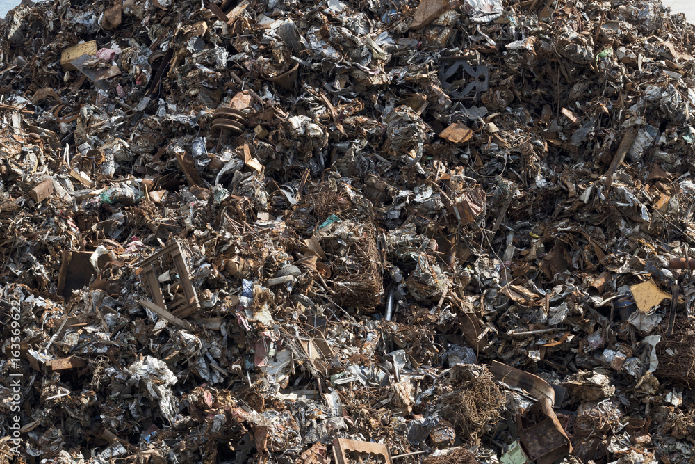 Background image of a mountain of rusty scrap metal.