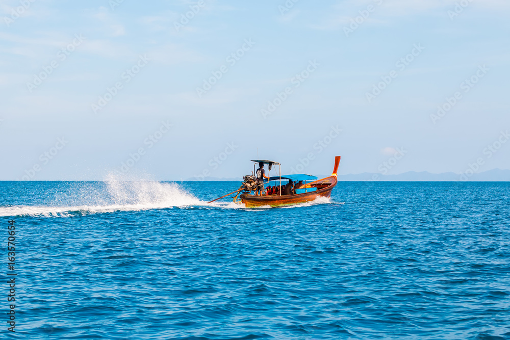 Fototapeta premium Long tail boat sailing on the blue sea