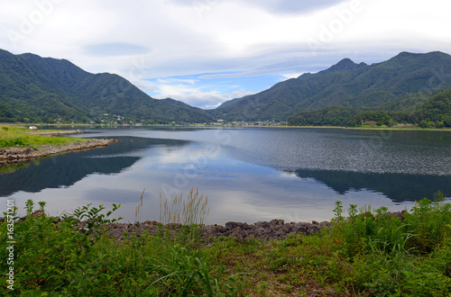 Peaceful nature scene with green mountains, trees and lake in Kawaguchiko near Mount Fuji, Japan © nyker