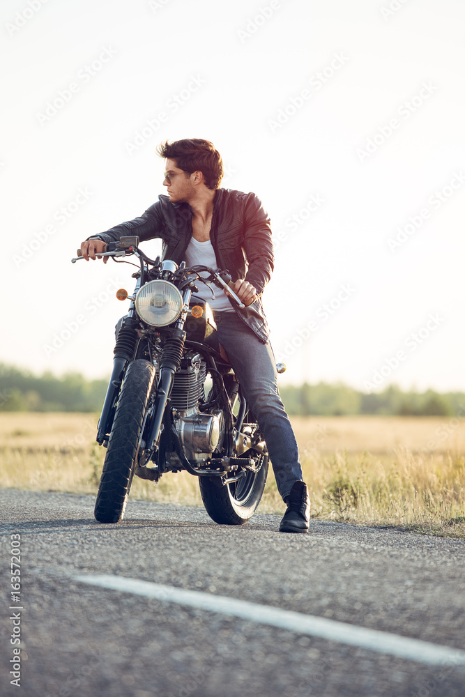 Obraz premium Motorcyclist with a cafe-racer motorcycle outdoors