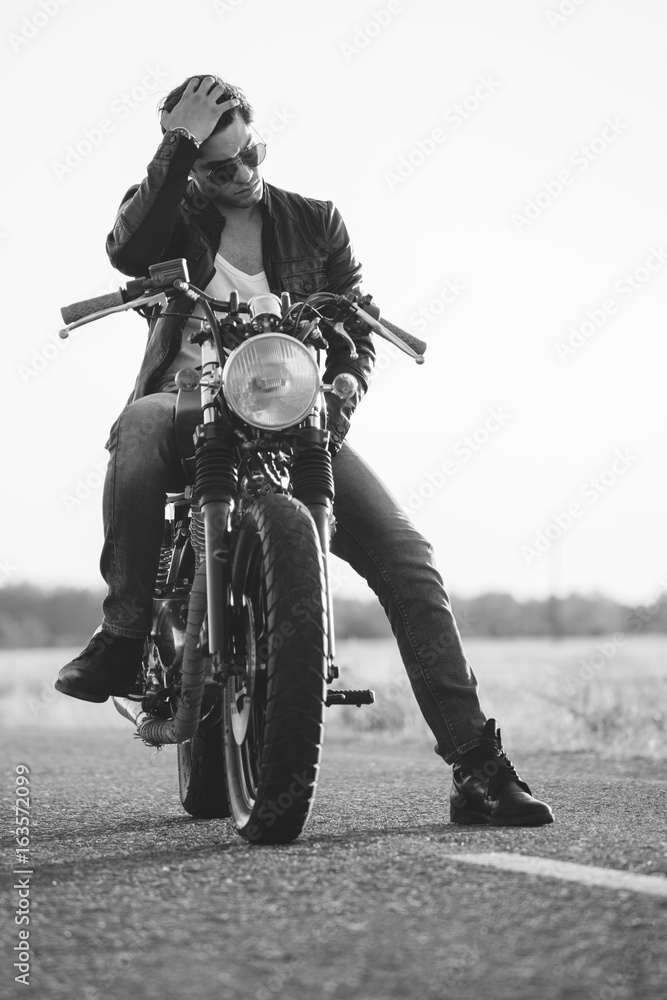 Naklejka premium Biker man sits on a bike