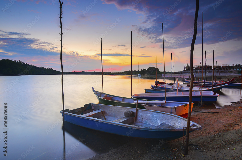 Fototapeta premium A row of fisherman boat at the river during sunset.