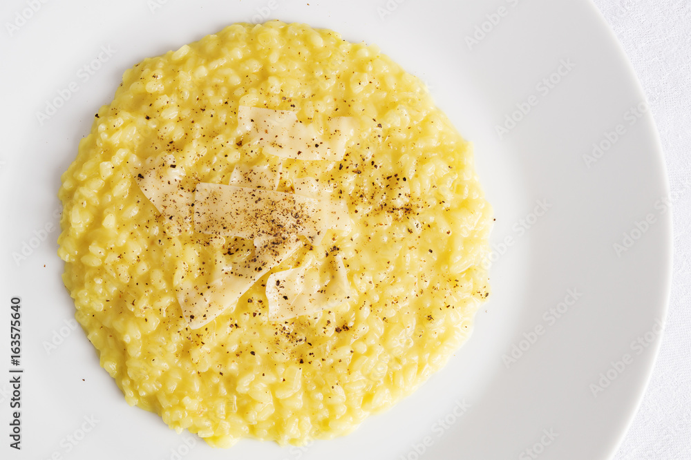 Fototapeta premium rice and onion cooked on broth coloured with saffron and white wine with cheese added