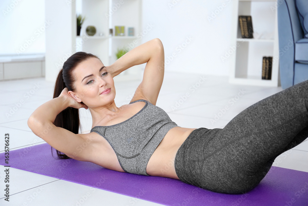 Attractive fitness woman exercising at home Attractive fitness woman exercising at home