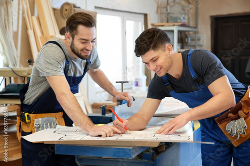 Two young carpenters checki...