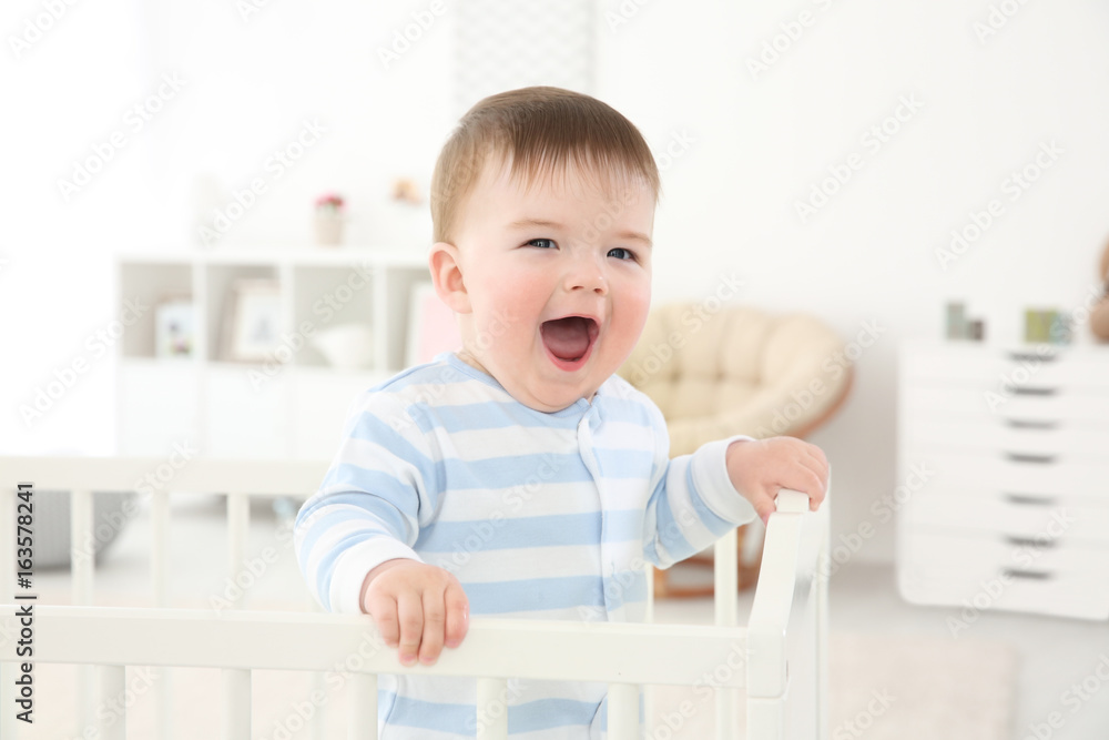 Cute little baby standing in crib at home Cute little baby standing in crib at home