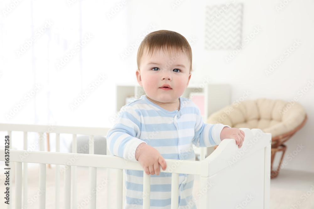 Cute little baby standing in crib at home Cute little baby standing in crib at home