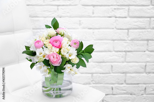 Beautiful bouquet with freesia flowers on white brick wall background