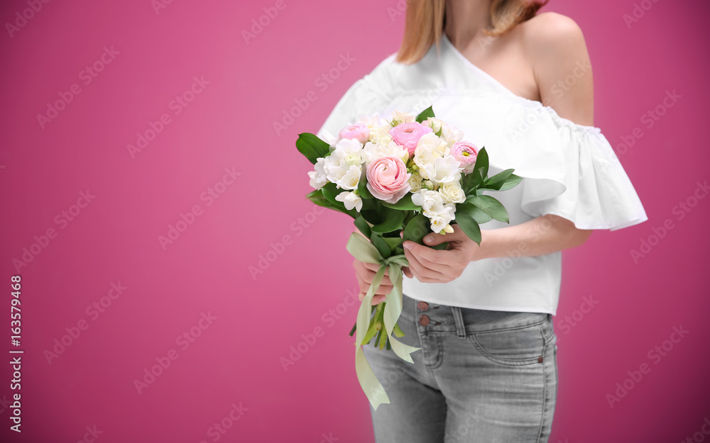 Young woman holding beautiful bouquet with white freesia on color background