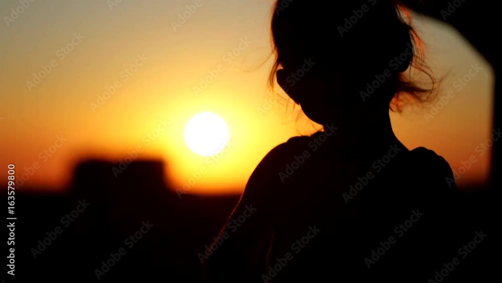 Little girl dancing in the sunset at the balcony. Silhouette close-up shot. Little girl dancing in the sunset at the balcony. Silhouette close-up shot.