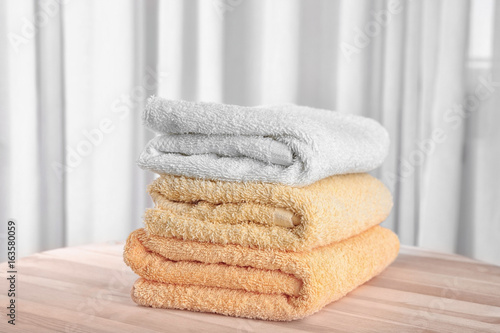 Stack of clean towels on wooden table