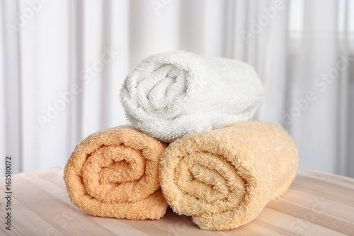Clean rolled towels on wooden table