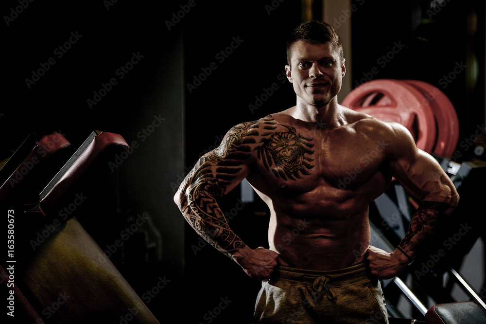 Fototapeta premium Strong and handsome athletic young tattoo man with muscles