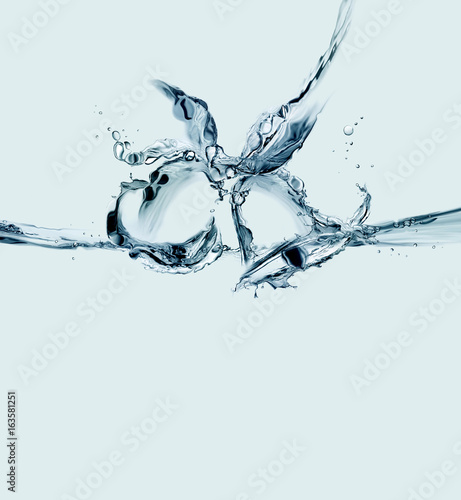 Two blue bells made of water in a ringing motion.
