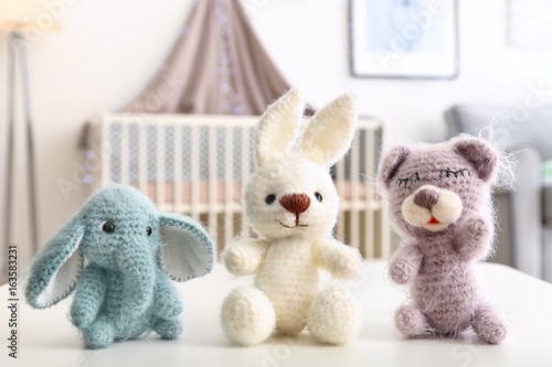 Adorable crochet baby toys on table in bedroom photo