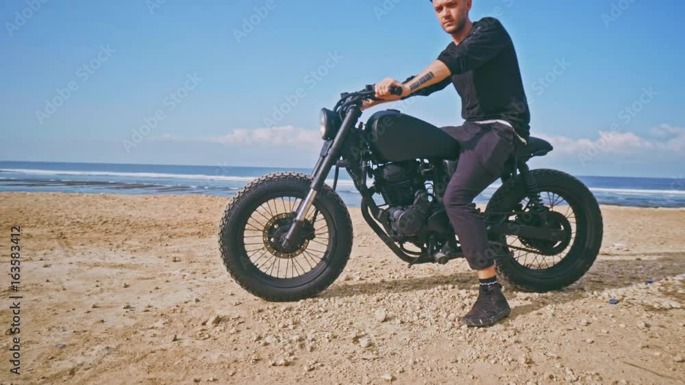 Motorcyclist driving his motorbike on the beach Motorcyclist driving his motorbike on the beach