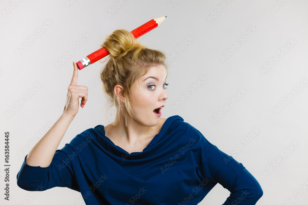 Shocked blonde woman having big pencil in hair Shocked blonde woman having big pencil in hair