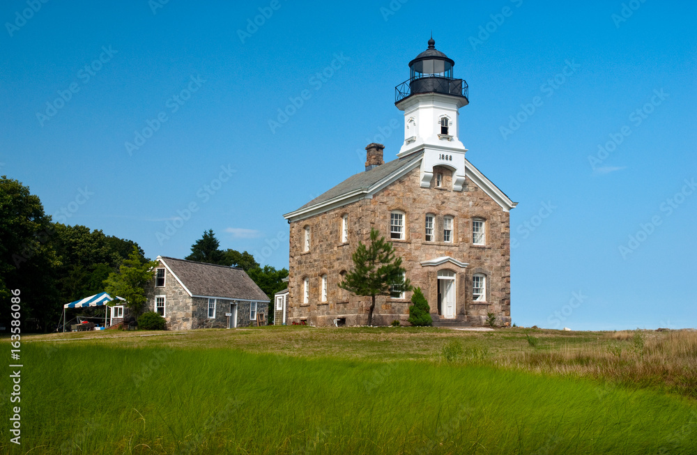 Sheffield Island lighthouse on a summer day in Connecticut. It is located on one of the Norwalk islands and hosts many events for tourists.