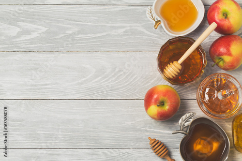 Rosh hashanah jewish new year holiday celebration concept. Honey and apples over wooden background. Top view